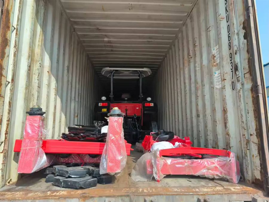 Tracteur et outils chargés en conteneur au départ de l'usine
